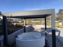 installation d'une pergola sur mesure à lames orientable pour un salon de jardin devant piscine à Chaponost